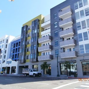 Modern multi-story residential building featuring balconies and commercial space at AV8 in Kettner Lofts.