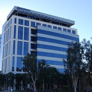 Qualcomm building features modern architecture with large glass windows and surrounding greenery.