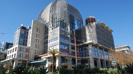 The modern exterior of the San Diego Central Library featuring a unique dome and surrounding greenery.