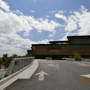 Modern exterior view of the Hollywood Casino Jamul, featuring clear skies and a winding pathway leading to the entrance.