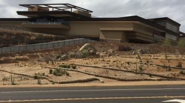 Hollywood Casino Jamul viewed from the roadside, showcasing its modern architecture against a partly cloudy sky.