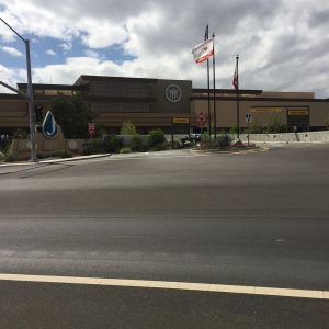 Hollywood Casino Jamul building with flags and signage, surrounded by a landscaped area and cloudy sky.
