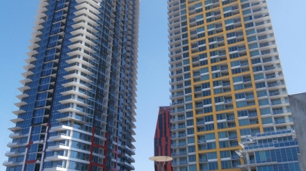 Two high-rise buildings of Pinnacle Bayview Phases I and II with modern architectural designs and clear blue sky backdrop.
